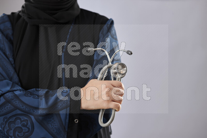 Female doctor wearing an abaya and medical attire in different positions