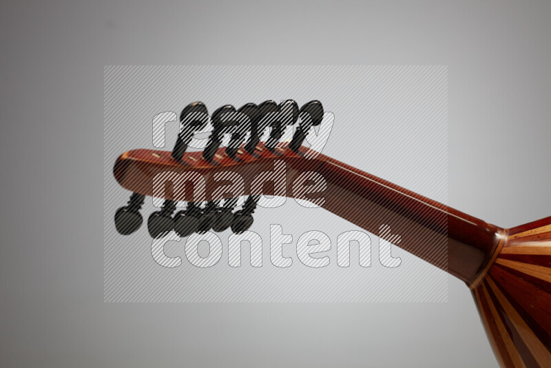 parts of a brown wooden Oud in a gray background