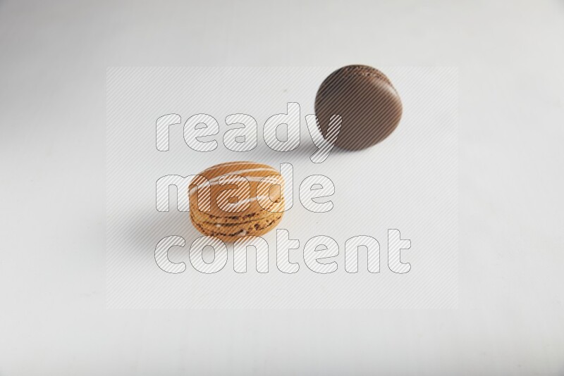 45º Shot of of two assorted Brown Irish Cream, and Brown Dark Chocolate macarons on white background
