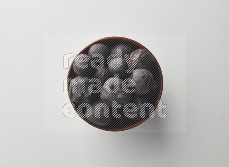 Top-view shot of dried lime (loomi) in a container on white background