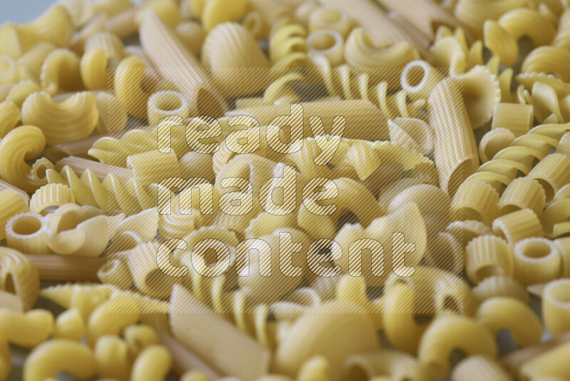 Different pasta types on light blue background