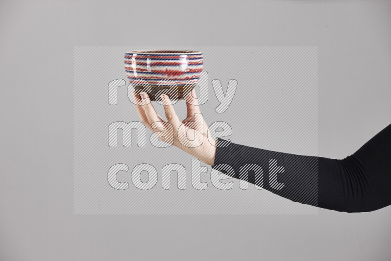 A woman in black abaya holding different pottery essentials in different positions