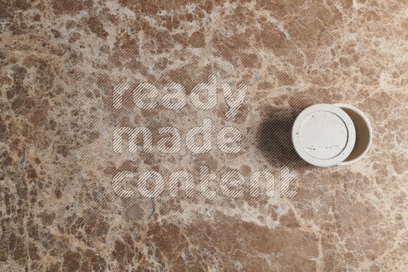 A pottery cup on beige marble background