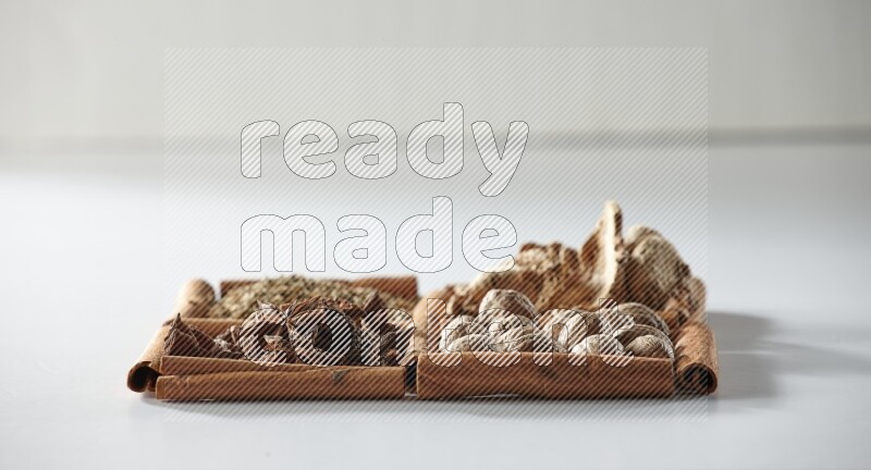 4 squares of cinnamon sticks full of star anise, ginger, cumin and nutmeg on white flooring