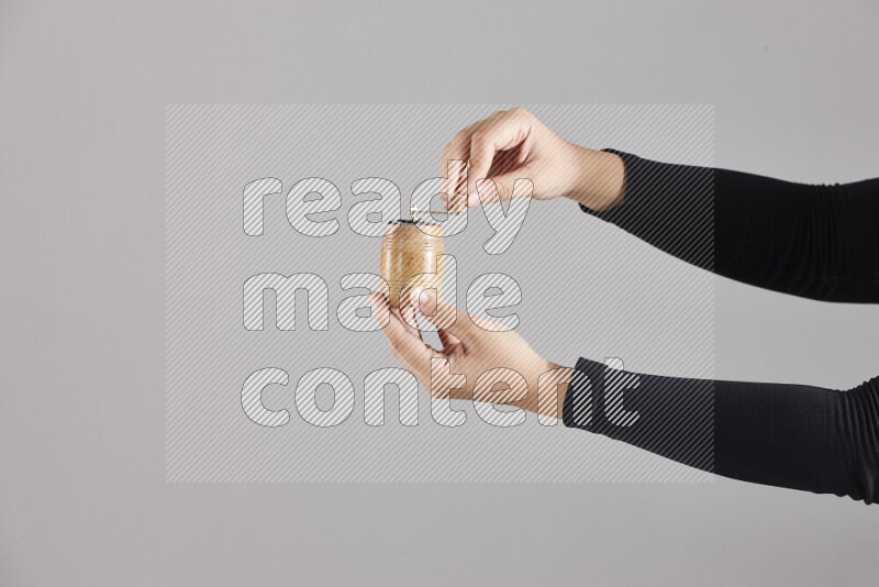 A woman in black abaya holding different wooden essentials in different positions
