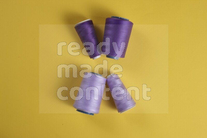 A purple collection of sewing and tailoring tools arranged on a yellow background