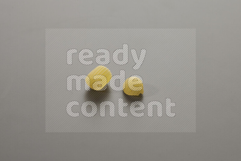 Big rings pasta with other types of pasta on grey background