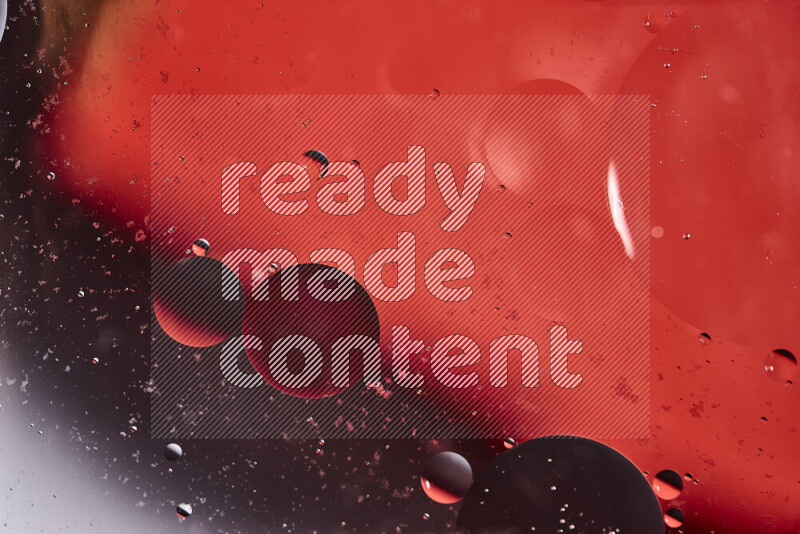 Close-ups of abstract oil bubbles on water surface in shades of black and orange