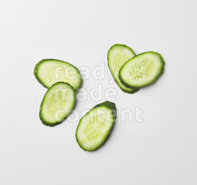 Multiple cucumber slices on white background