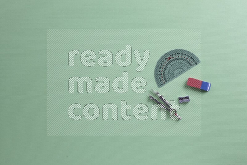 Different school supplies on green background