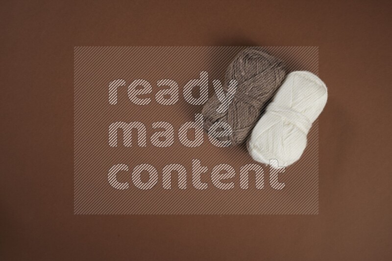 A white and brown collection of sewing and tailoring tools arranged on a brown background