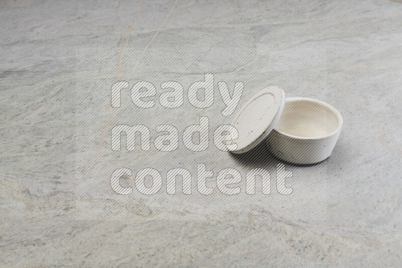 A white pottery bowl on grey marble background