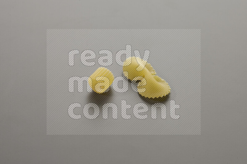 Big rings pasta with other types of pasta on grey background