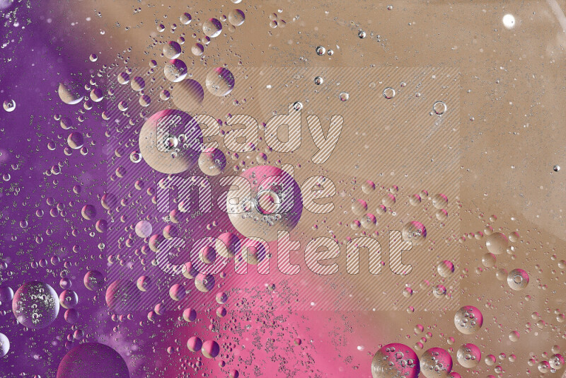 لقطات مقربة لفقاعات من الزيت على سطح الماء باللون البني والأرجواني والوردي