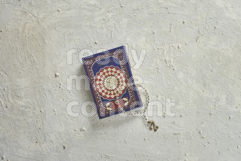 Quran with a prayer beads on white background
