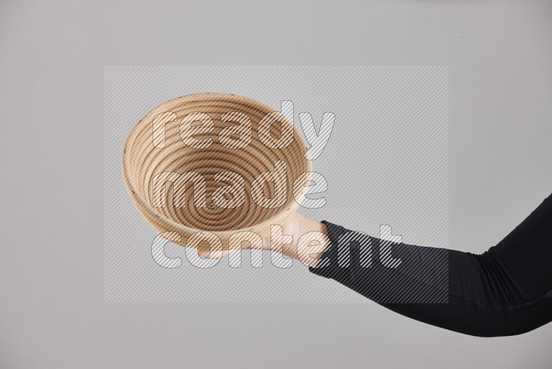 A woman in black abaya holding different wooden essentials in different positions