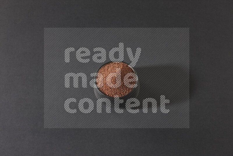 وعاء فخاري أسود ممتلئ ببذور حب الرشاد على أرضية سوداء