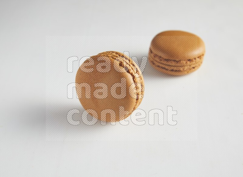 45º Shot of two Brown Maple Taffy macarons on white background