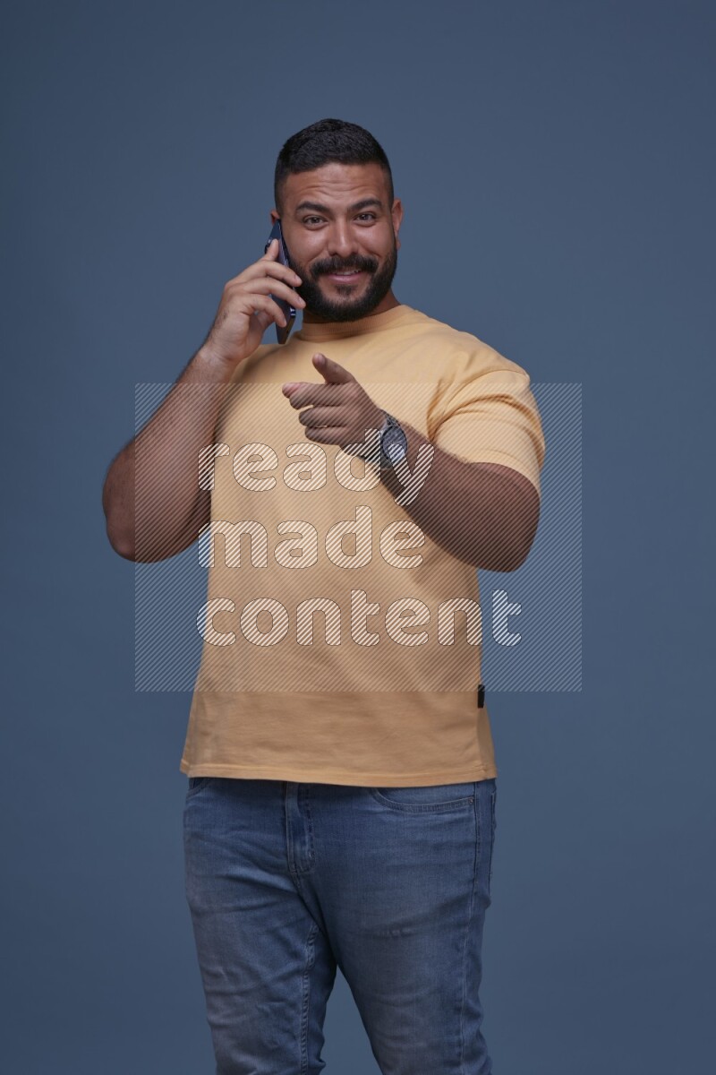 A man Calling on Blue Background wearing Orange T-shirt