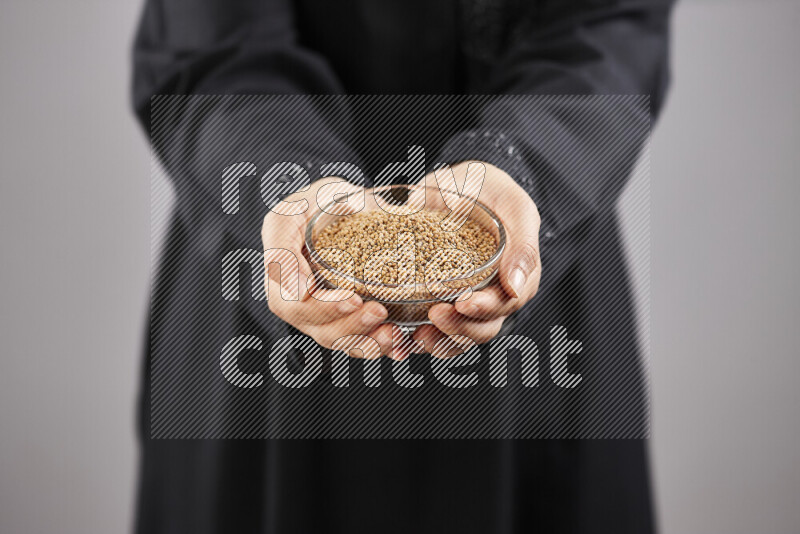 Woman in abaya holding different kinds of spices in different positions