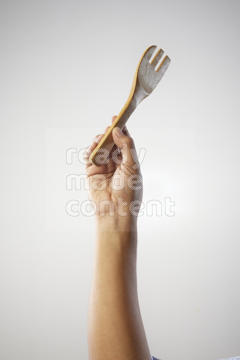 Male Hand Holding Wooden Fork on white  background