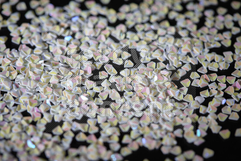 Colorful plastic shards for decoration scattered on a black background