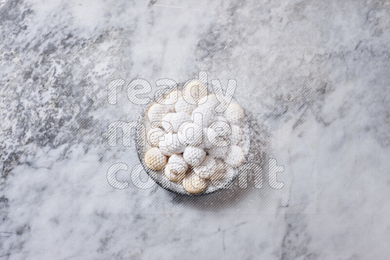 كحك في صحن فخار أسود على خلفية رخام رمادي