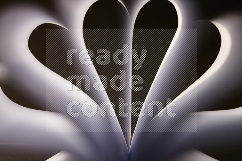 An abstract art piece displaying smooth curves in grey gradients created by colored light