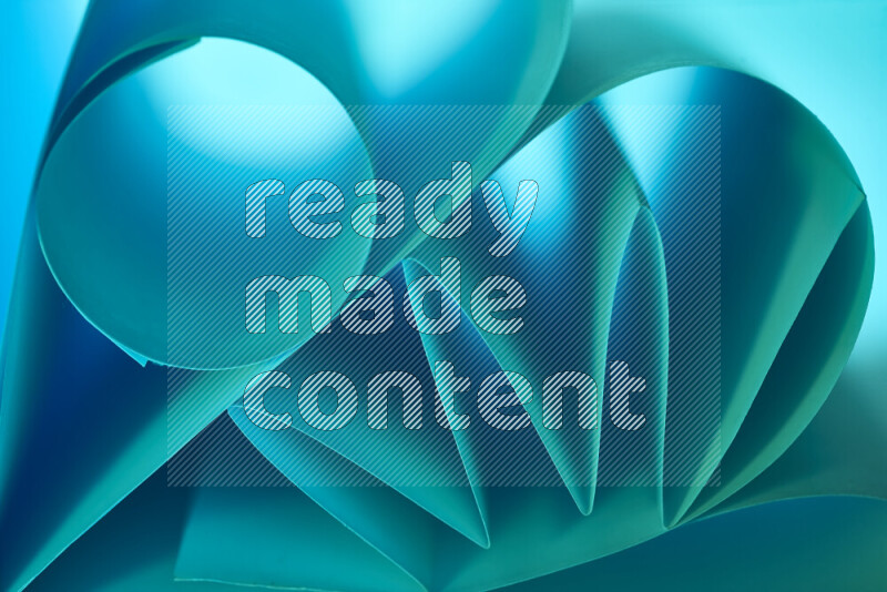 An artistic display of paper folds creating a harmonious blend of geometric shapes, highlighted by soft lighting in green and blue tones