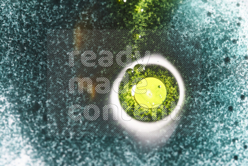 Close-ups of abstract green and yellow watercolor drops on oil Surface on white background