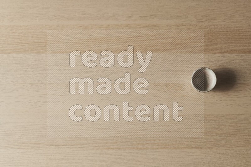 كأس فخاري على خلفية خشبية فاتحة