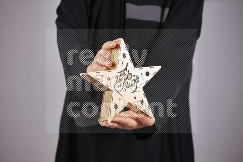 امرأة ترتدي عباءة سوداء تحمل فوانيس رمضانية مختلفة في أوضاع متعددة