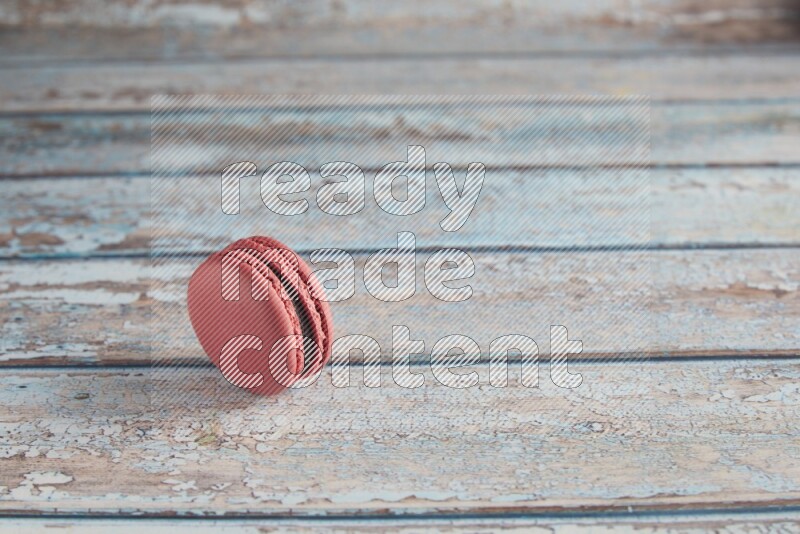 45º Shot of Pink Raspberry macaron on light blue wooden background