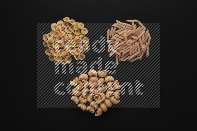 Different pasta types in bunches on black background