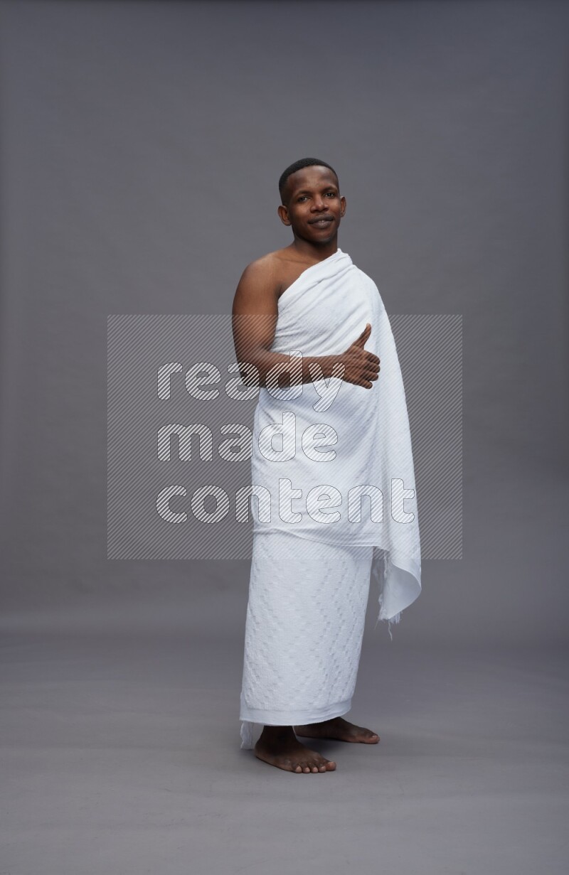 A man wearing Ehram Standing Interacting with the camera on gray background