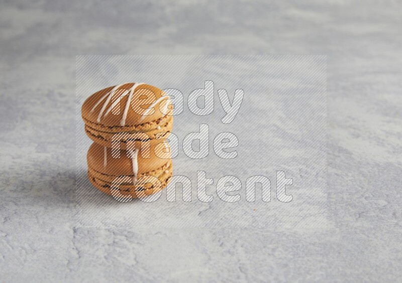 45º Shot of two Brown Irish Cream macarons  on white  marble background