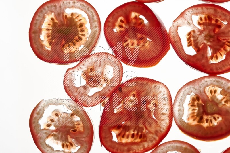 Tomatoes slices on illuminated white background