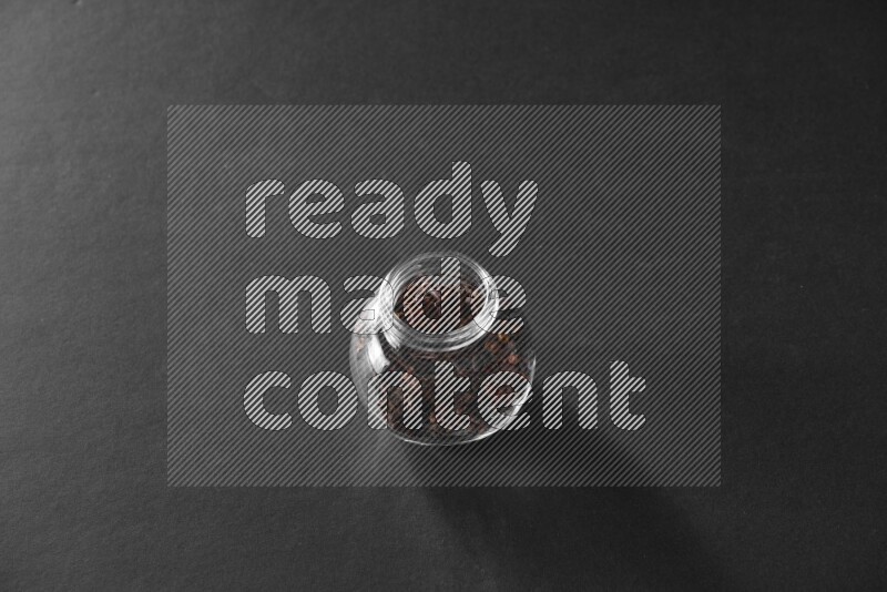 قرنفل في وعاء زجاجي علي خلفية سوداء