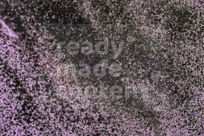 Close-ups of abstract green watercolor drops on oil Surface on pink background