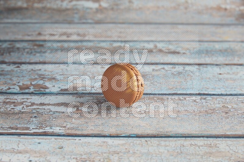 45º Shot of Brown Coffee macaron on light blue wooden background