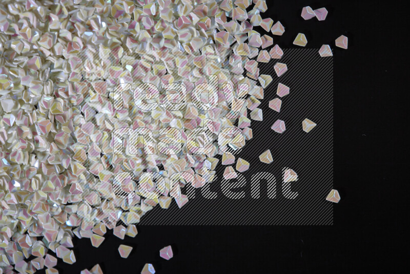 Colorful plastic shards for decoration scattered on a black background