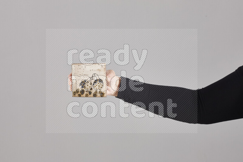A woman in black abaya holding different pottery essentials in different positions