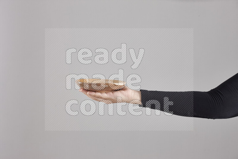 A woman in black abaya holding different pottery essentials in different positions