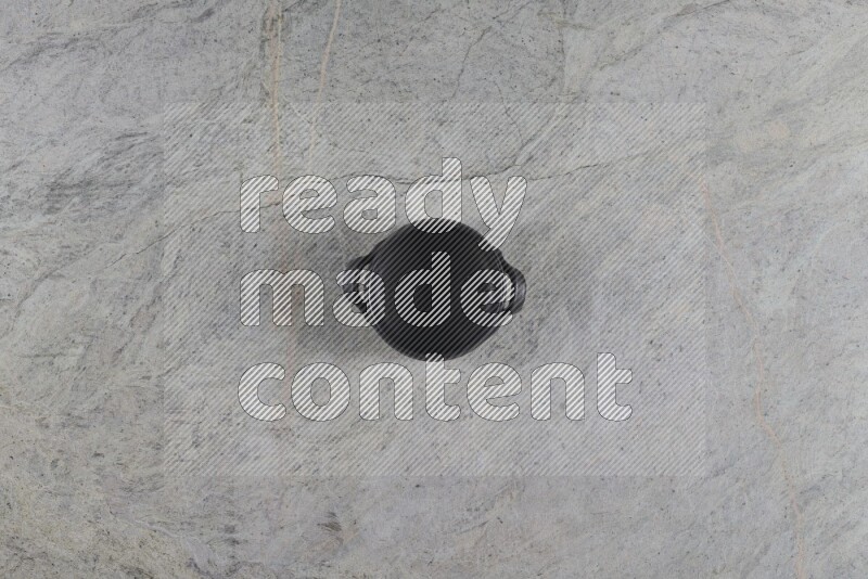 A black pottery bowl on grey marble background