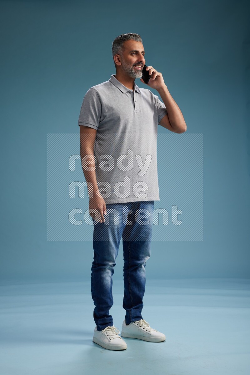 Man Standing talking on phone on blue background