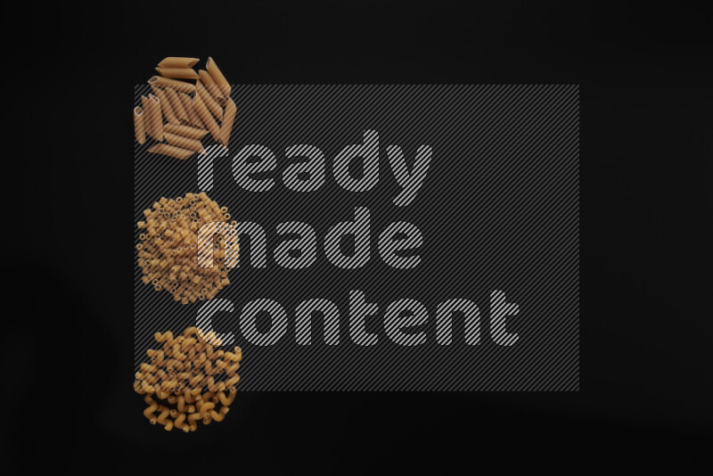 Different pasta types in 3 bunches on black background