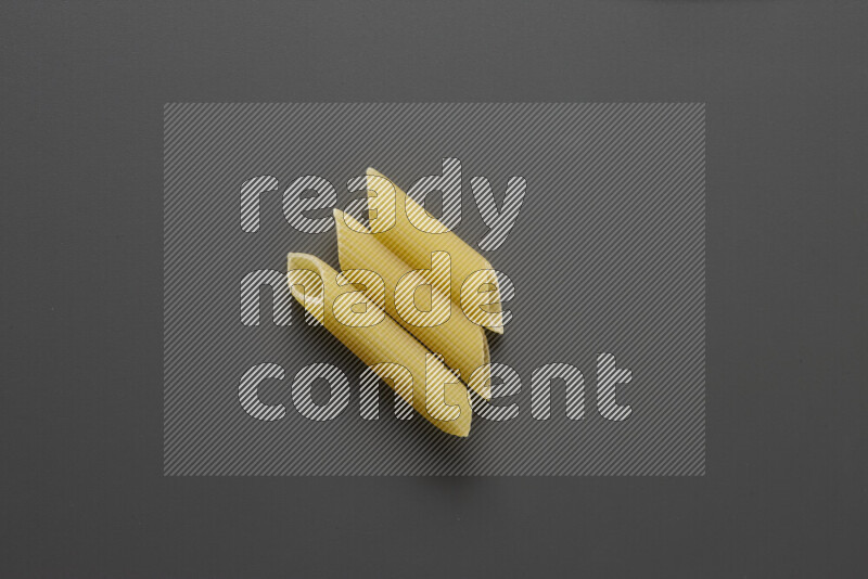 Penne pasta on grey background