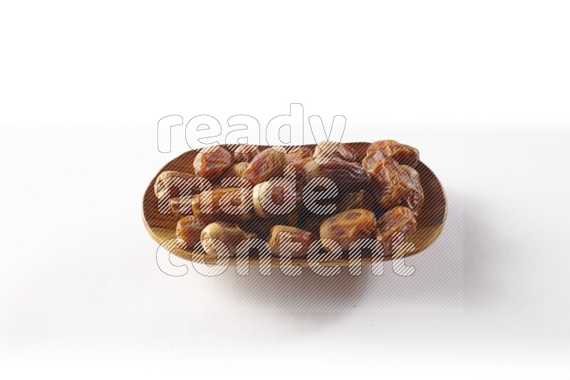 Dates in a wooden plate on white background