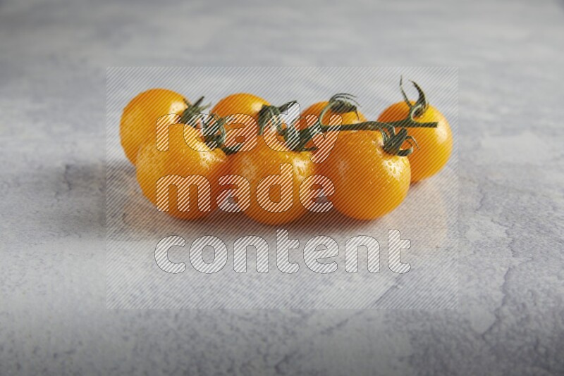 Yellow cherry tomato vein on a light grey textured background 45 degree