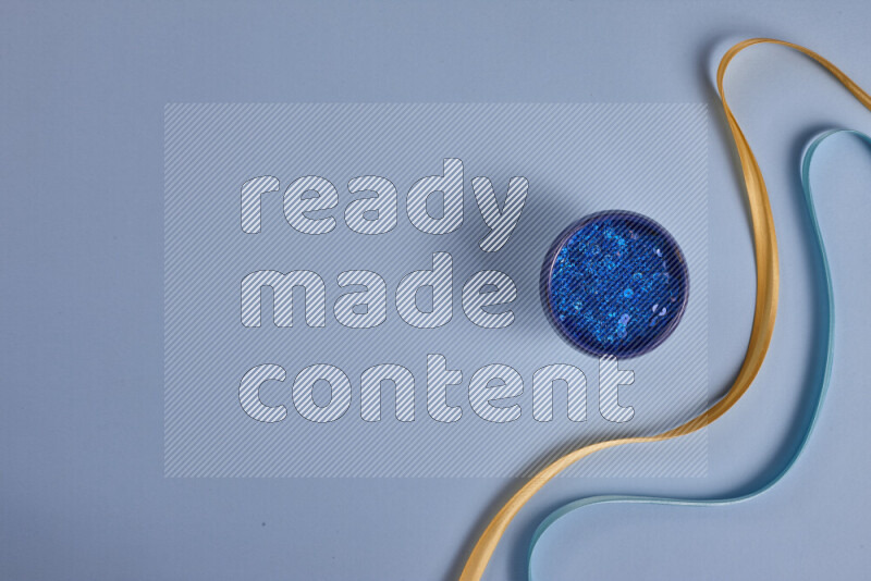 مجموعة من أدوات الخياطة والتفصيل صفراء وزرقاء اللون على خلفية زرقاء